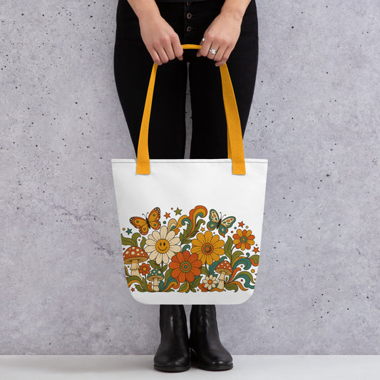 Retro 70s psychedelic tote bag featuring smiley daisies, red spotted mushrooms, and colorful butterflies on black.