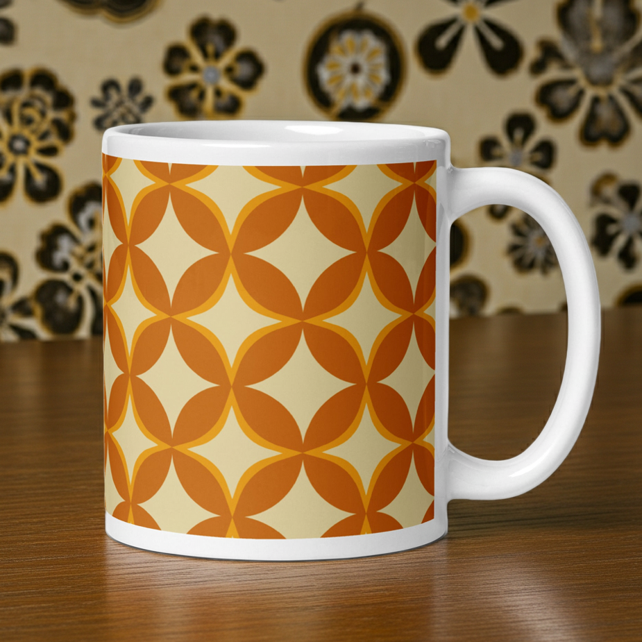 Ceramic coffee mug with a 1970s retro geometric pattern of interlocking orange and mustard petal shapes.