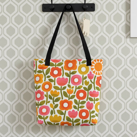 Retro 1970s flower power pattern tote bag featuring geometric orange, pink, and yellow flowers with green leaves