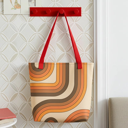 Retro 70s curved stripe pattern in earth tones, brown, and orange printed on a durable polyester everyday tote bag.