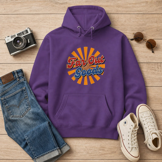 A purple pullover hoodie with a retro 'Fan Out Goods' sunburst graphic on the chest, styled in a flat lay on a light wood background with jeans, sneakers, sunglasses, and a camera.