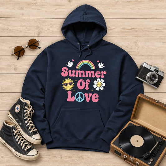 A navy blue hoodie with a colorful retro 'Summer Of Love' graphic, styled in a flat lay on a light wood background with sunglasses, Converse sneakers, a vintage camera, and a record player.