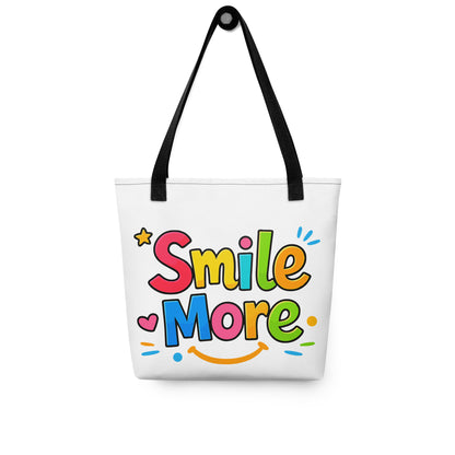 Colorful bubbly text reading "Smile More" with a yellow sun-smile and pink heart on a black canvas tote bag.