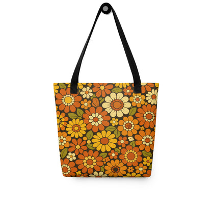 Retro 70s floral pattern polyester tote bag with orange, yellow, and cream daisies on a dark brown background.
