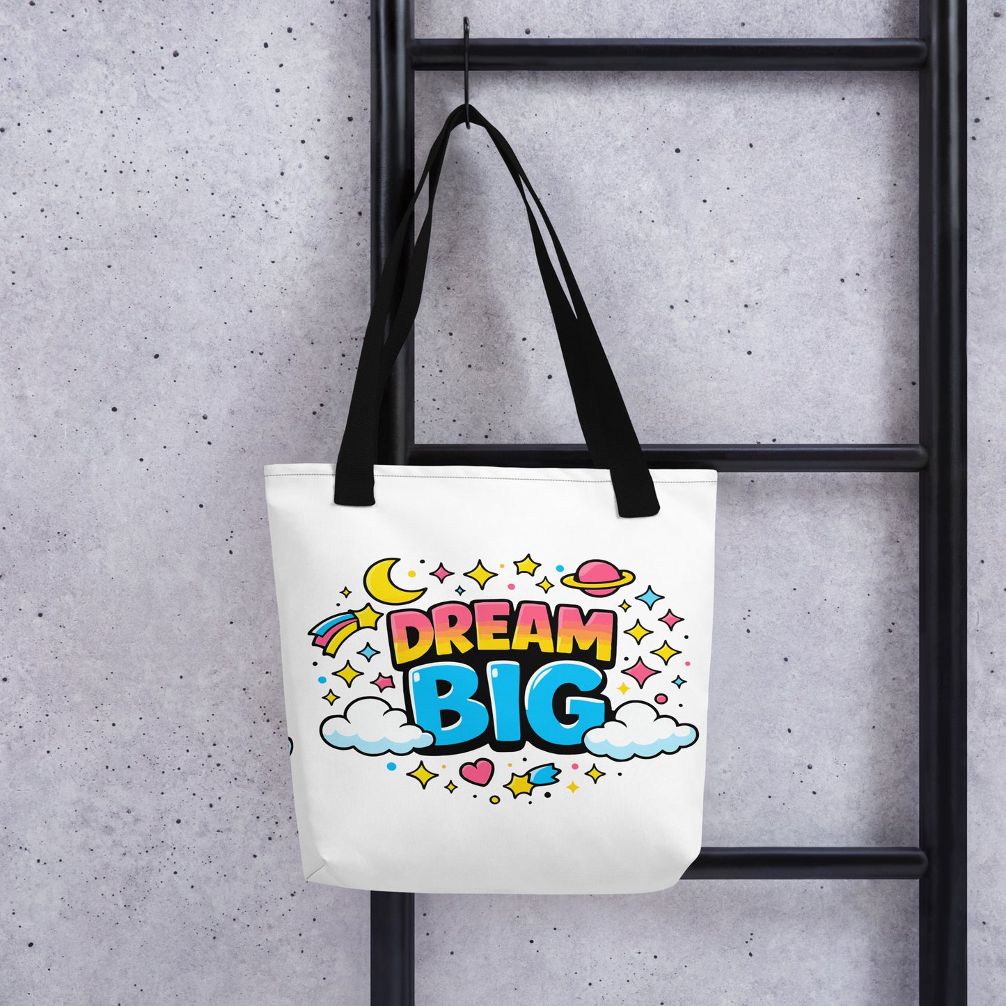 Colorful "Dream Big" text with stars, planets, and clouds in a retro 70s style on a black background tote bag.