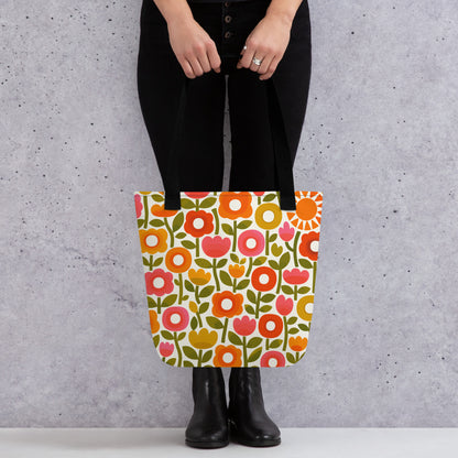 Retro 1970s flower power pattern tote bag featuring geometric orange, pink, and yellow flowers with green leaves