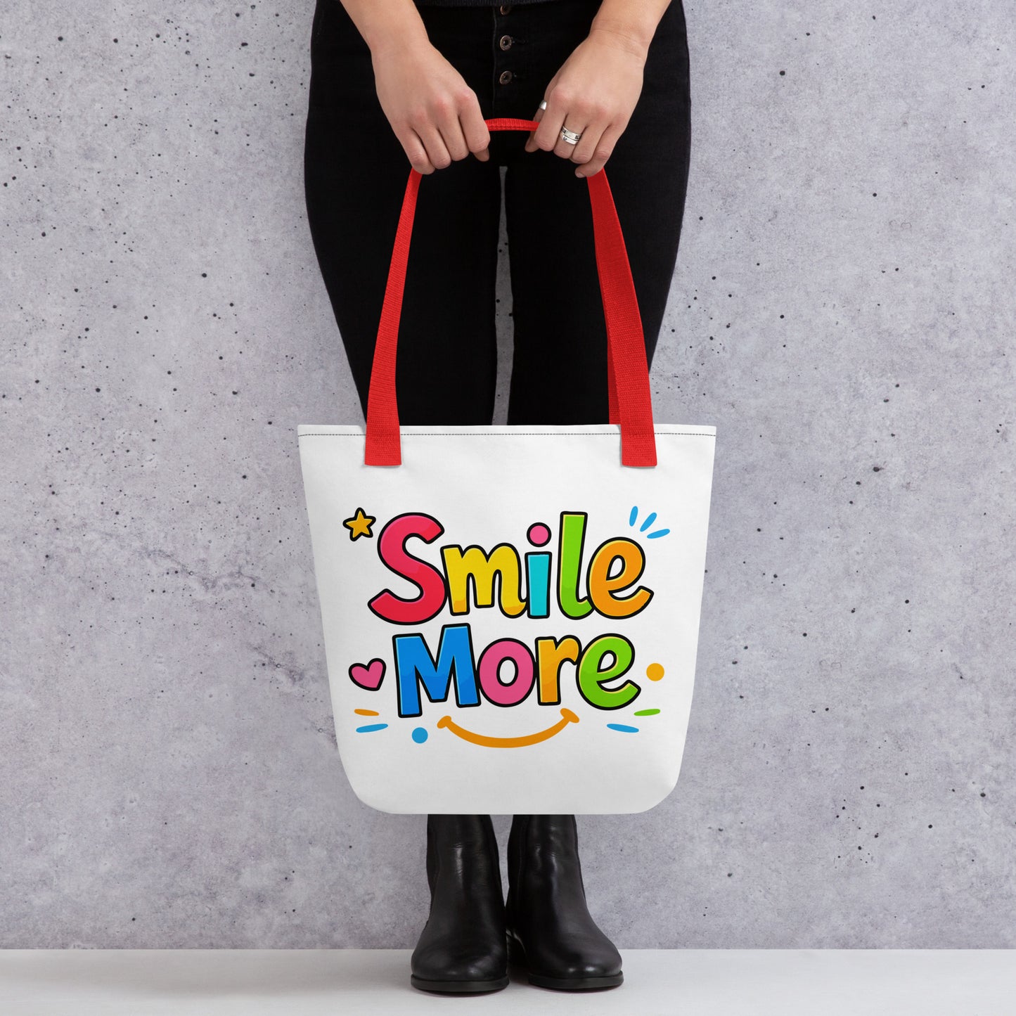 Colorful bubbly text reading "Smile More" with a yellow sun-smile and pink heart on a black canvas tote bag.