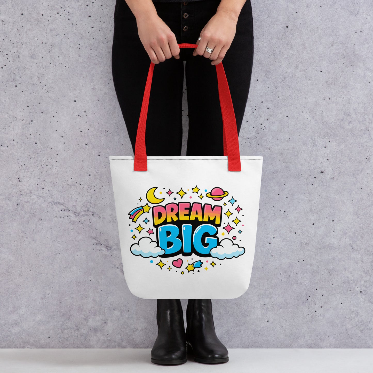 Colorful "Dream Big" text with stars, planets, and clouds in a retro 70s style on a black background tote bag.