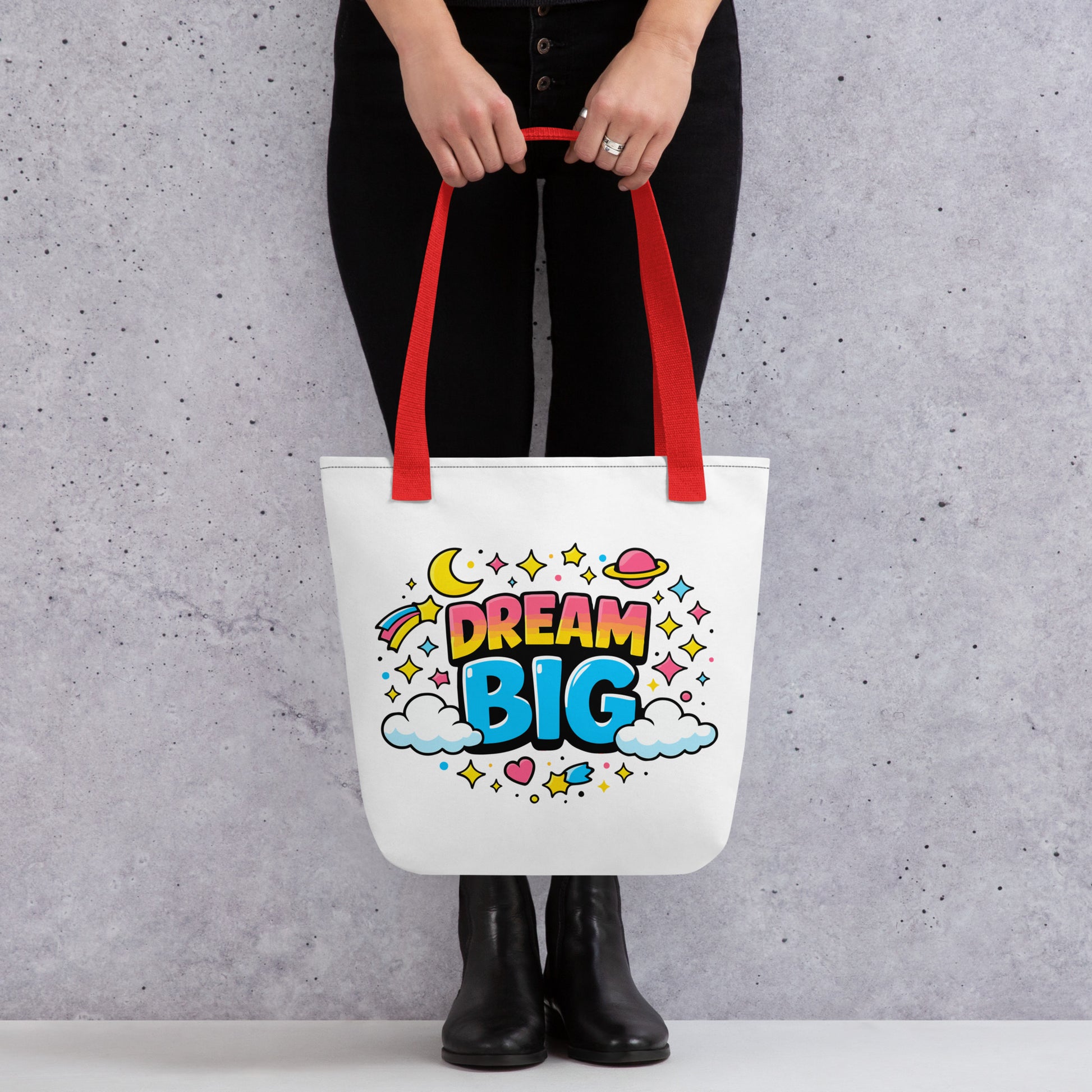 Colorful "Dream Big" text with stars, planets, and clouds in a retro 70s style on a black background tote bag.
