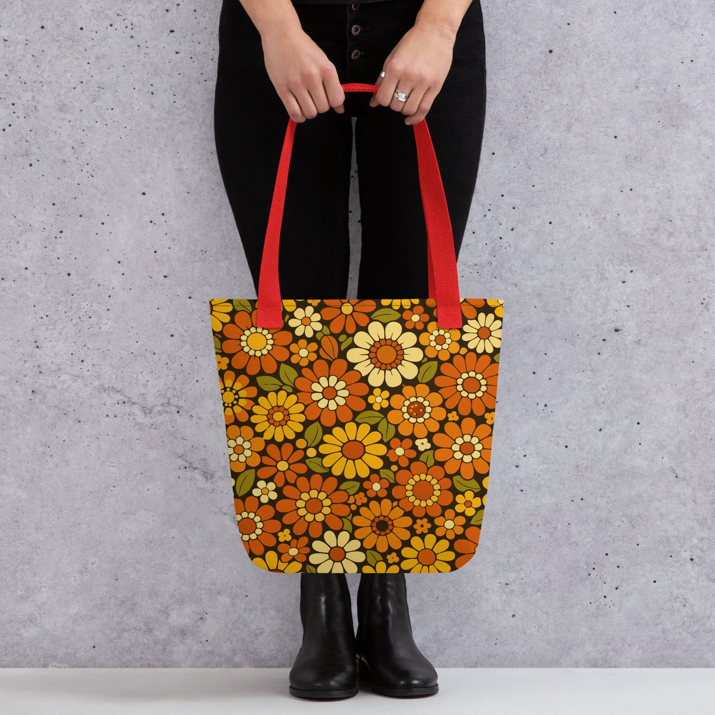 Retro 70s floral pattern polyester tote bag with orange, yellow, and cream daisies on a dark brown background.