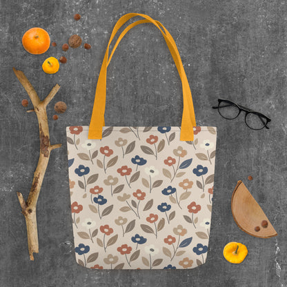 Canvas tote bag with a retro 70s mod flower pattern featuring large stylized blossoms in mustard yellow, burnt orange, and cream on a white background.
