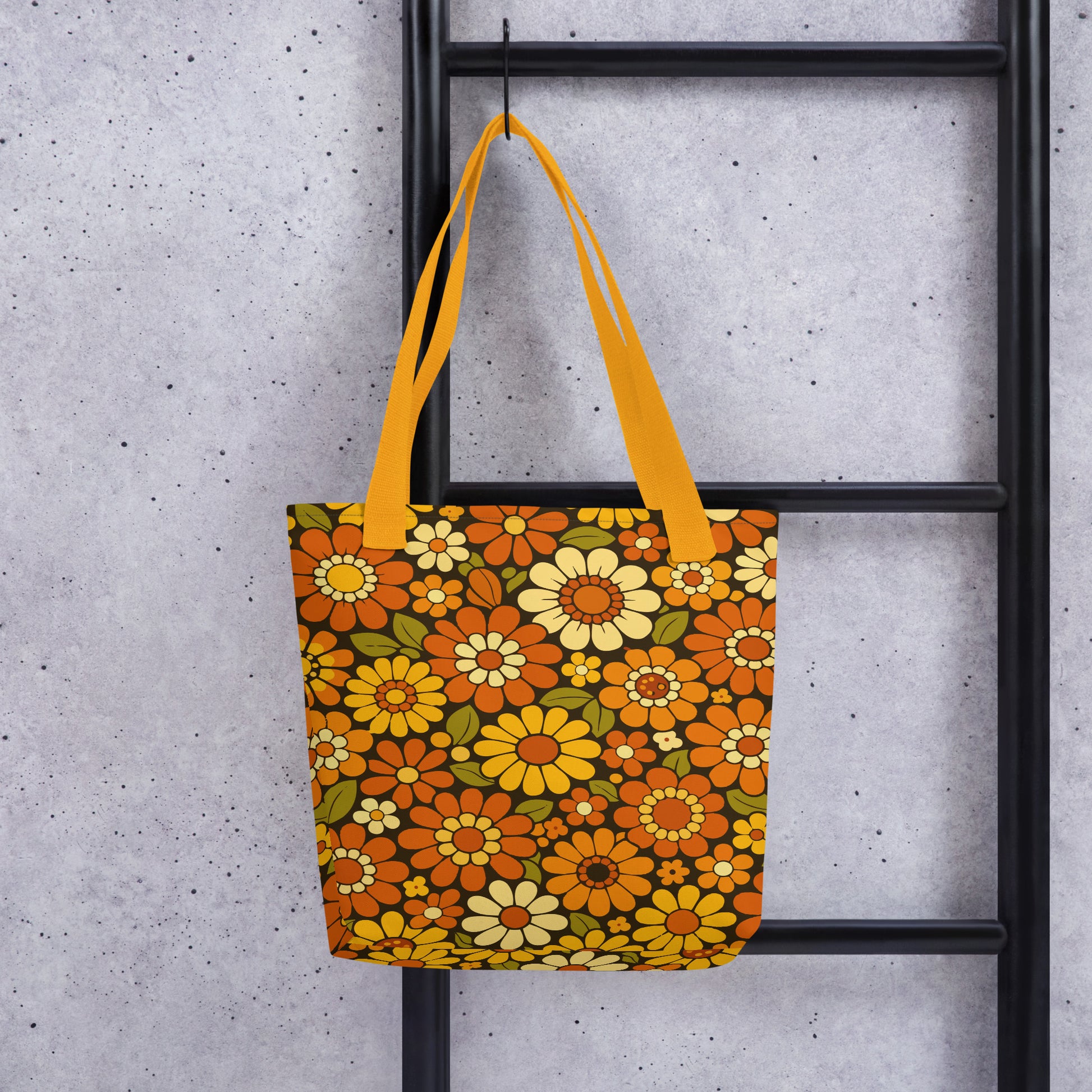 Retro 70s floral pattern polyester tote bag with orange, yellow, and cream daisies on a dark brown background.