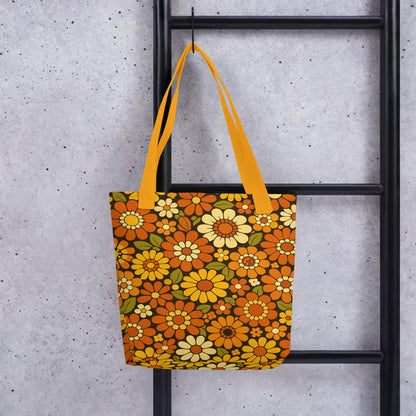 Retro 70s floral pattern polyester tote bag with orange, yellow, and cream daisies on a dark brown background.