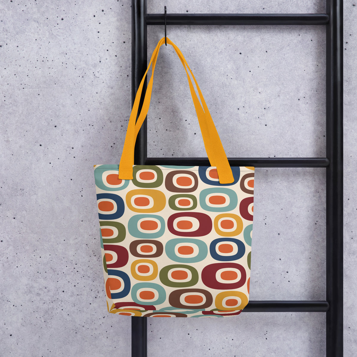 Retro 1970s mid-century modern geometric oval pattern tote bag printed with colorful mustard, orange, teal, and navy shapes