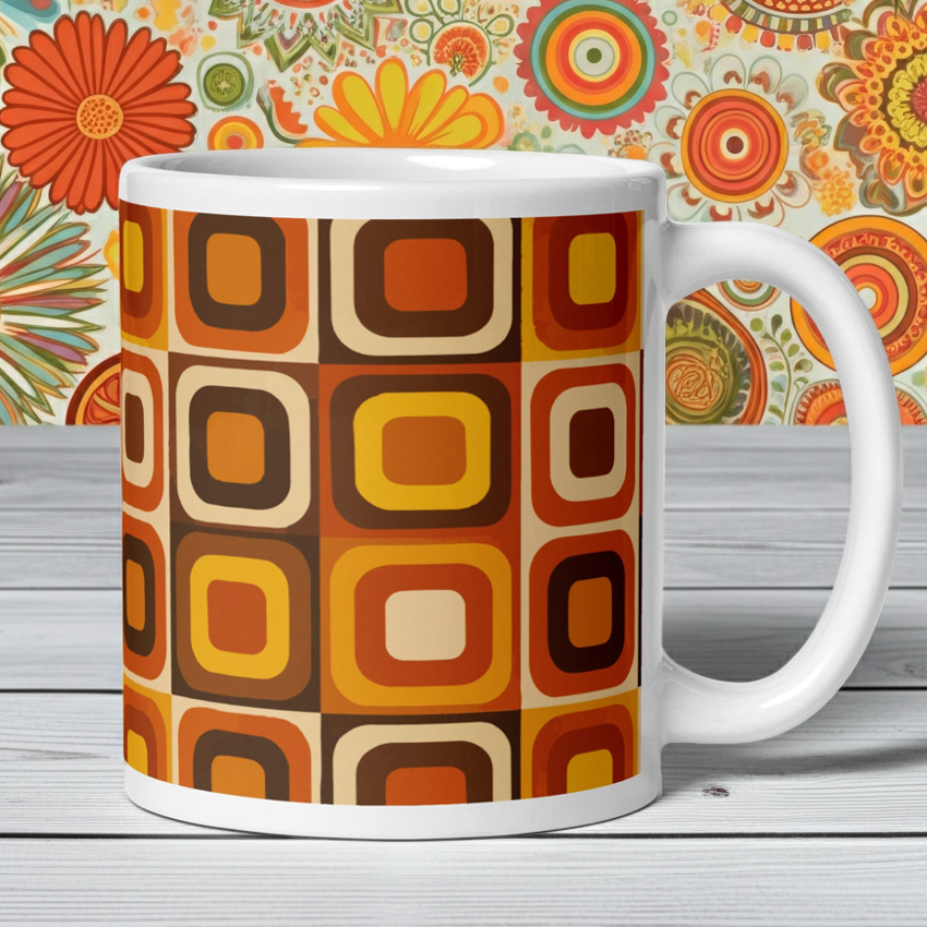 Glossy white ceramic coffee mug featuring a retro 70s-style geometric pattern with earth-toned orange, brown, and cream interlocking shapes.