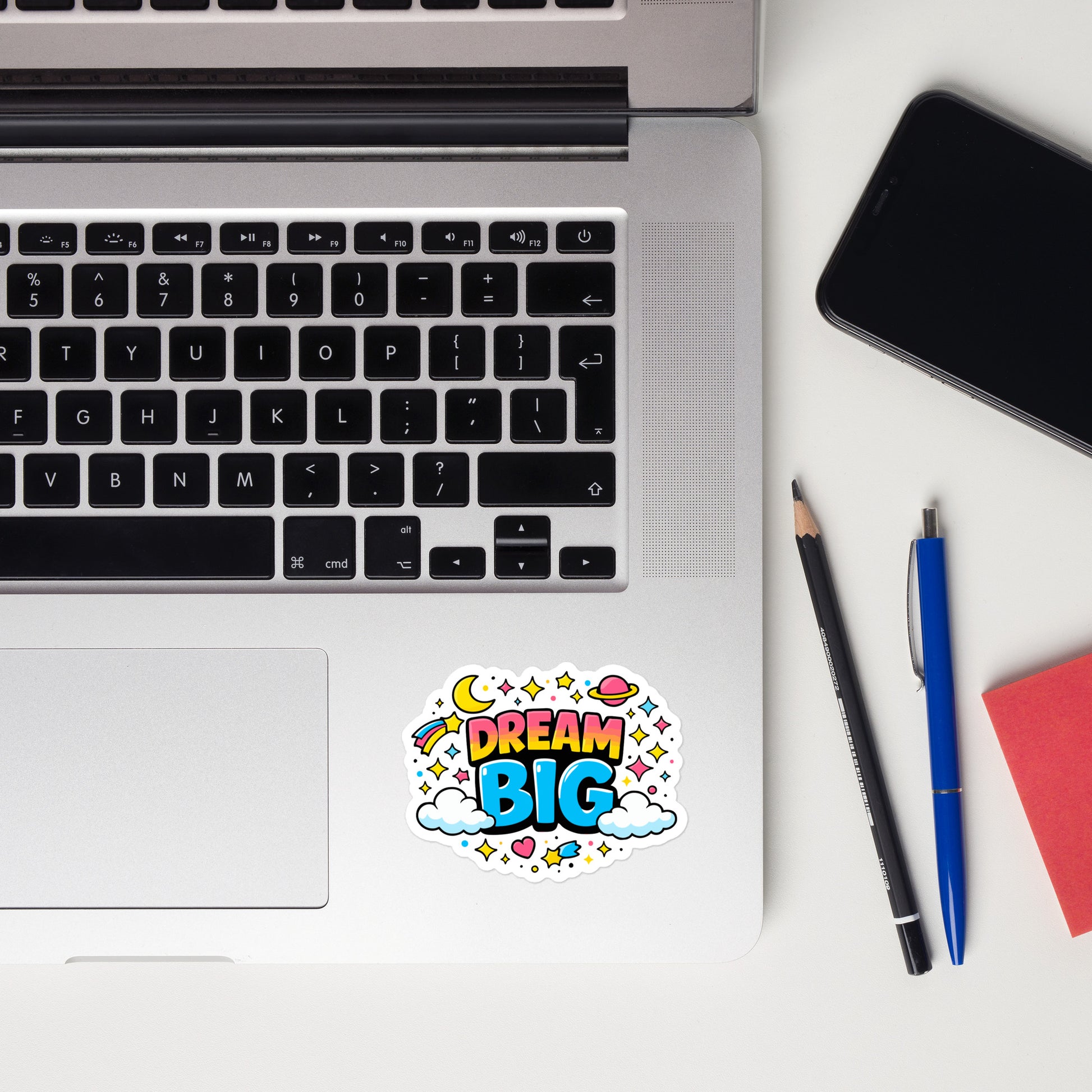 Dream Big, text surrounded by yellow stars, a pink planet, and white clouds on a black background.