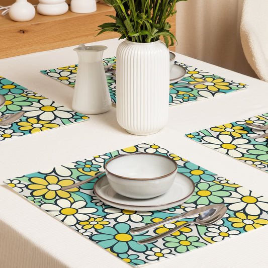 Top-down view of four retro placemats featuring a colorful 1970s psychedelic daisy pattern with teal and yellow flowers.