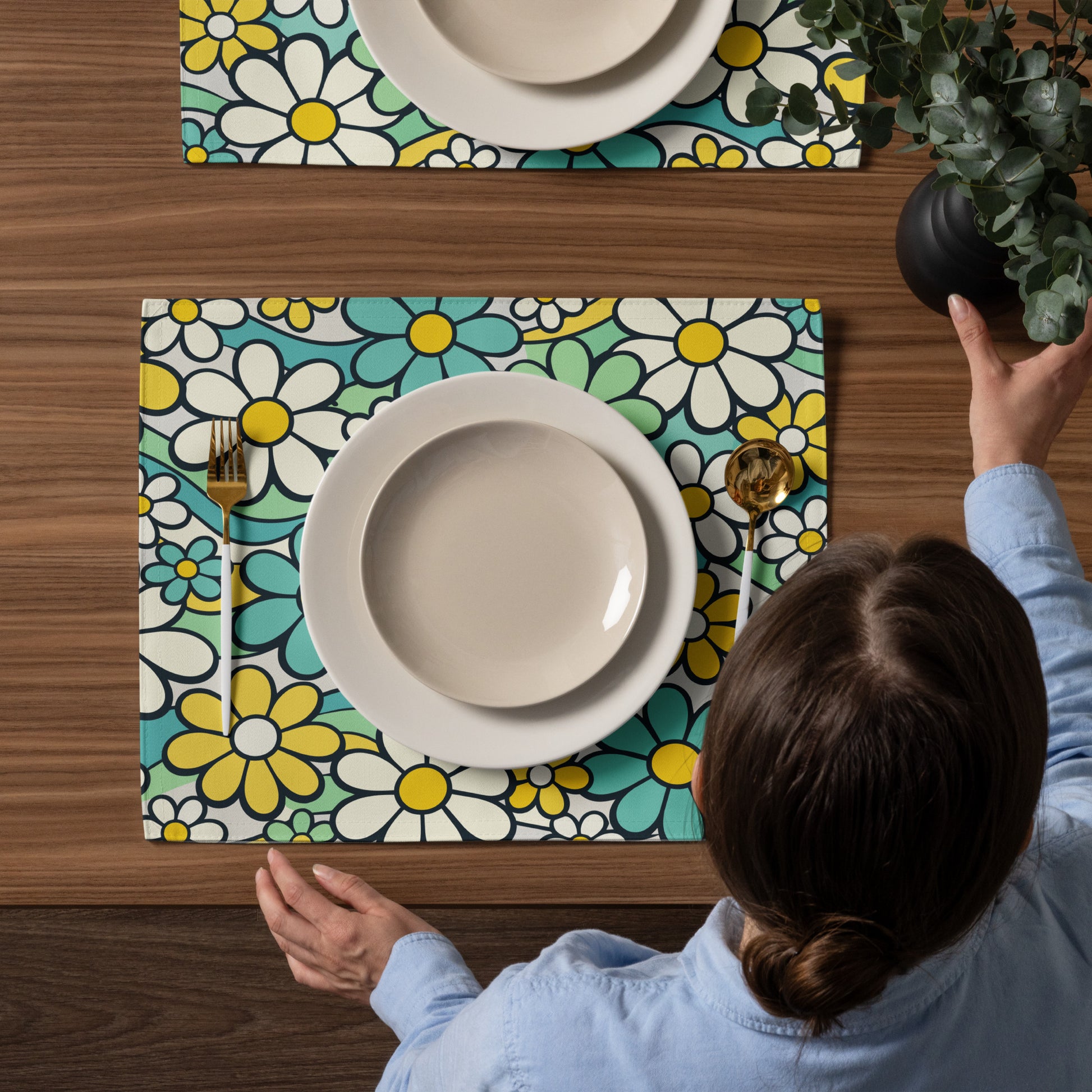 Top-down view of four retro placemats featuring a colorful 1970s psychedelic daisy pattern with teal and yellow flowers.