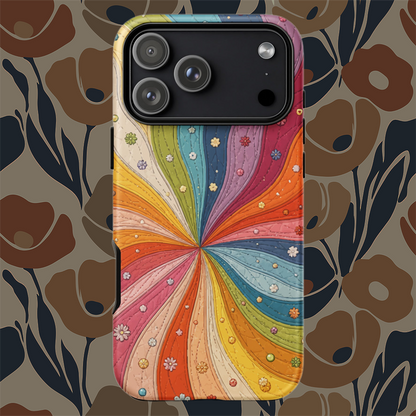 Flexible TPU iPhone case featuring a vibrant retro 70s quilted rainbow swirl design with stitched details and tiny flowers.
