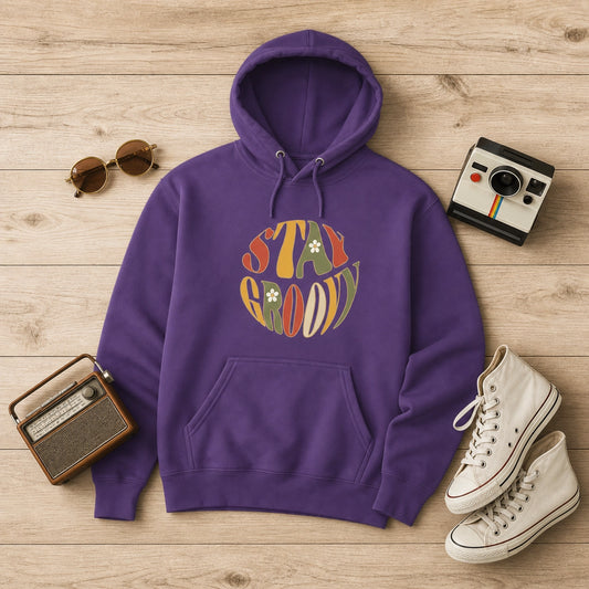 Unisex hoodie featuring a "Stay Groovy" vintage 70s floral design with vibrant orange and yellow flowers on a soft fabric base.