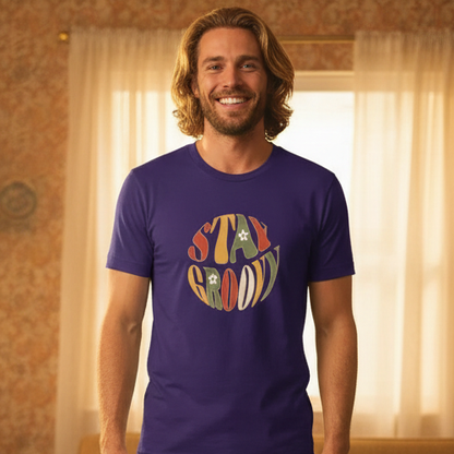 Unisex t-shirt featuring a Stay Groovy retro 70s floral design with vibrant orange and yellow flowers on a premium fabric.