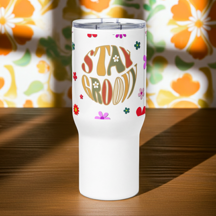 Insulated travel mug with handle featuring a Stay Groovy retro 70s floral pattern in vibrant orange and yellow tones.