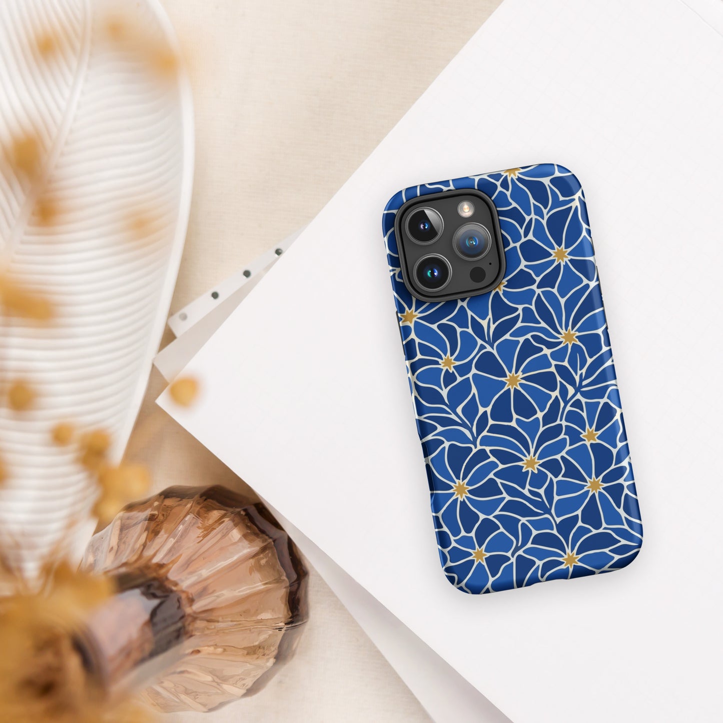 Vibrant blue mosaic floral pattern iPhone case with navy petals and gold star centers by Far Out Goods.