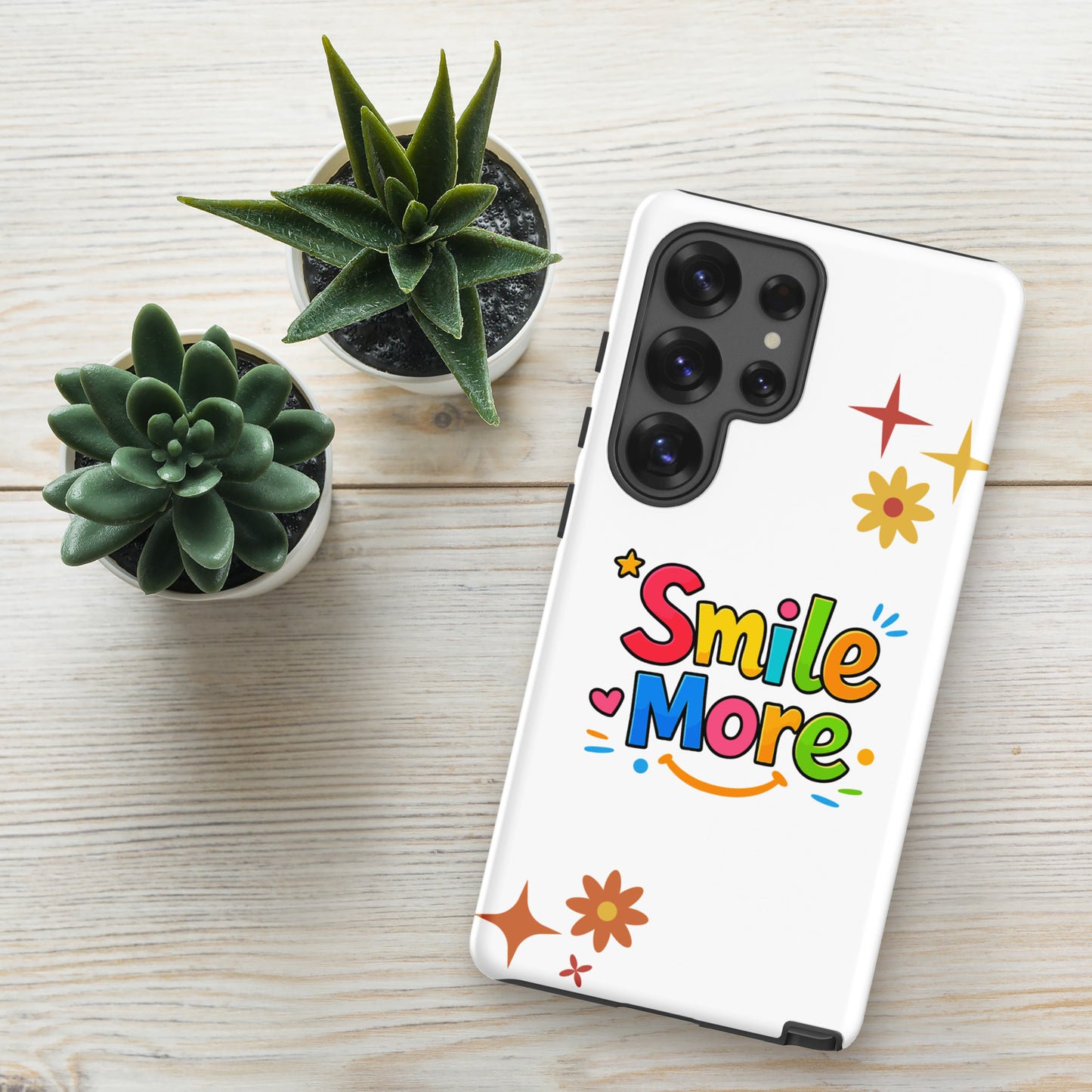 Smile More, bubbly lettering with a yellow sun-smile and pink heart on a black Samsung Galaxy phone case.