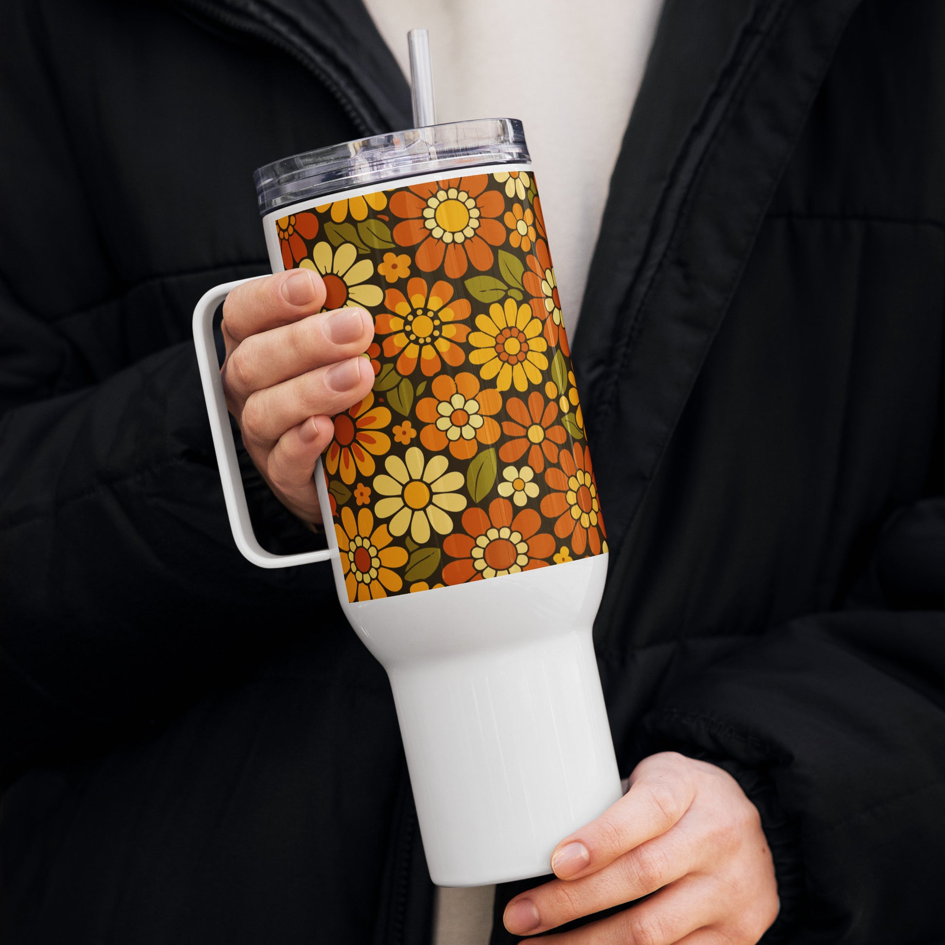 Retro 70s floral pattern stainless steel travel mug with orange, yellow, and cream daisies on a dark brown background.