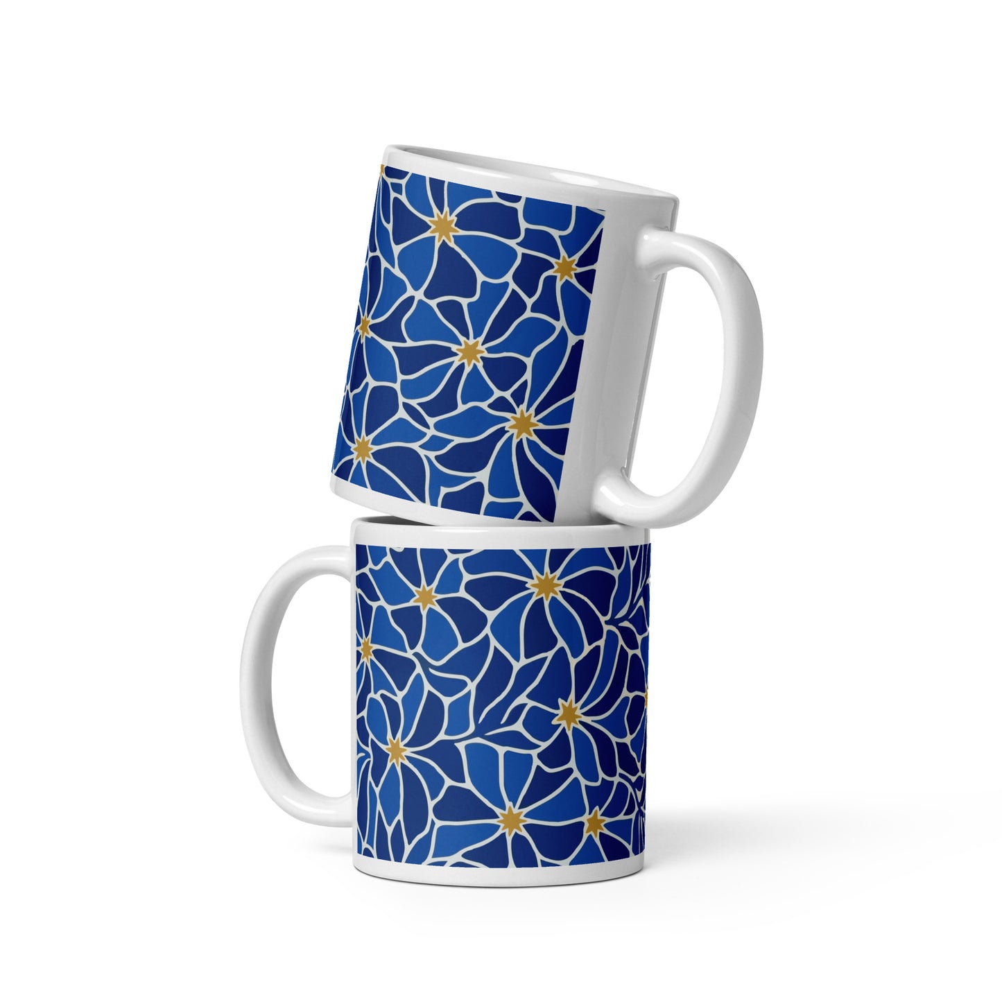 Ceramic coffee mug with a vibrant blue mosaic floral pattern and golden star centers by Far Out Goods.