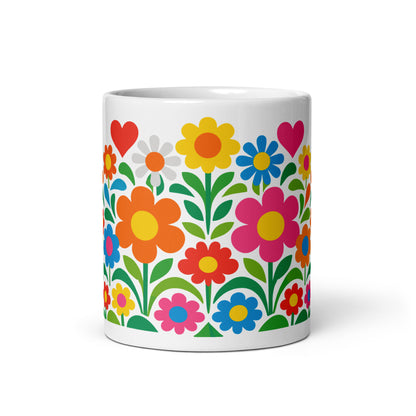 Vibrant 70s retro flower power bouquet with colorful blooms and pink and red hearts on a white ceramic mug.