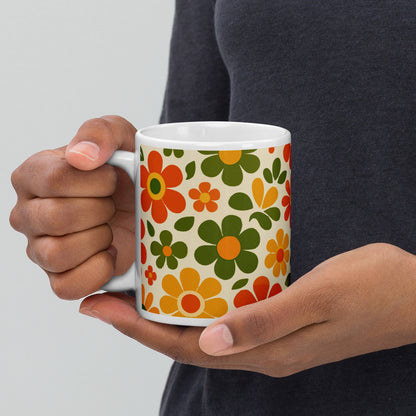Groovy 1970s retro flower power pattern printed on a ceramic coffee mug with vibrant orange and yellow daisy graphics.