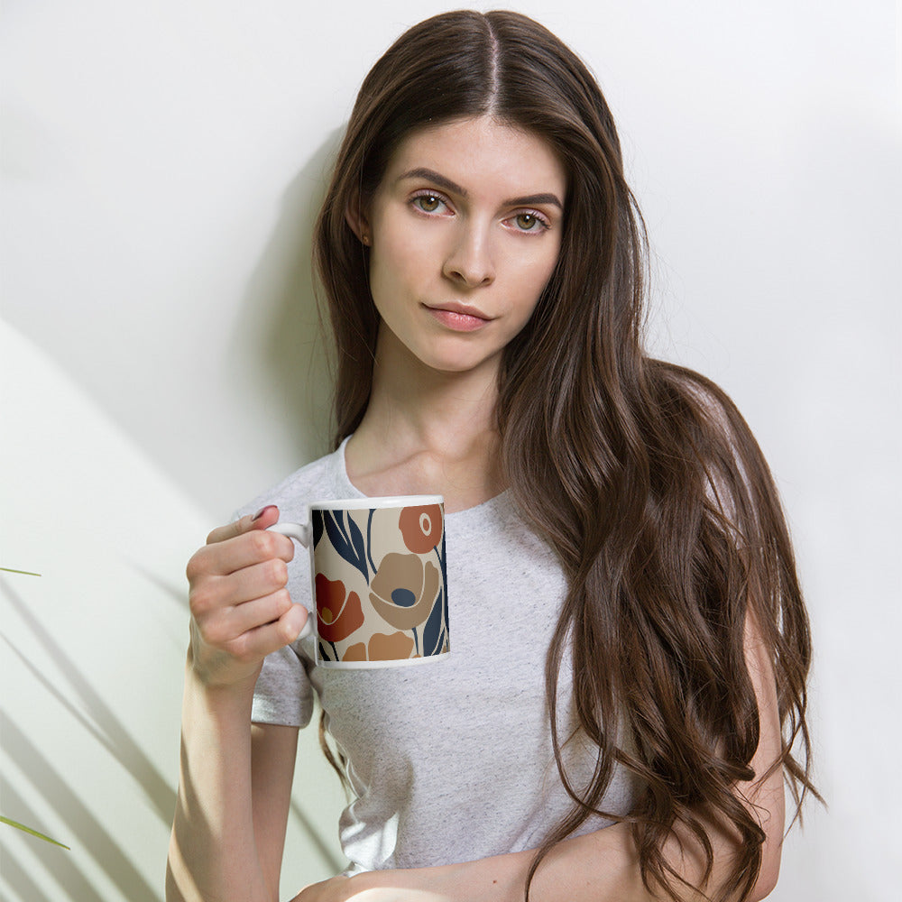 Ceramic coffee mug printed with a seamless retro floral pattern in earthy terracotta, ochre, and deep navy blue.