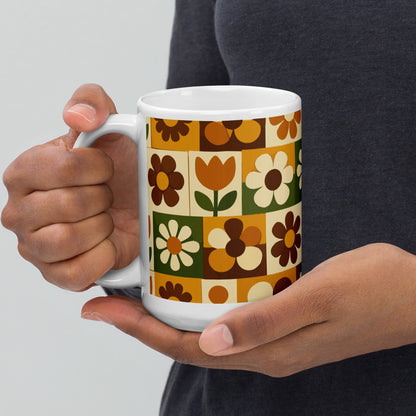 Ceramic mug featuring a 1970s retro floral grid pattern with groovy flowers in orange, brown, and olive green.