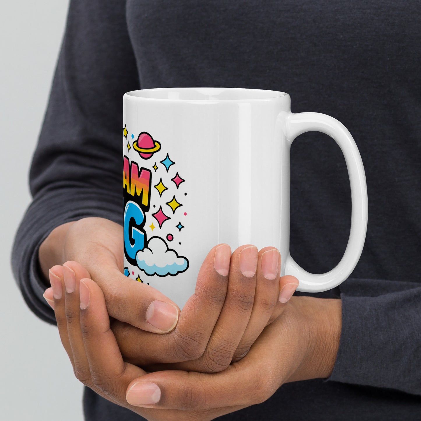Vibrant "Dream Big" typography with a pink planet, yellow moon, and colorful stars on a black ceramic coffee mug.