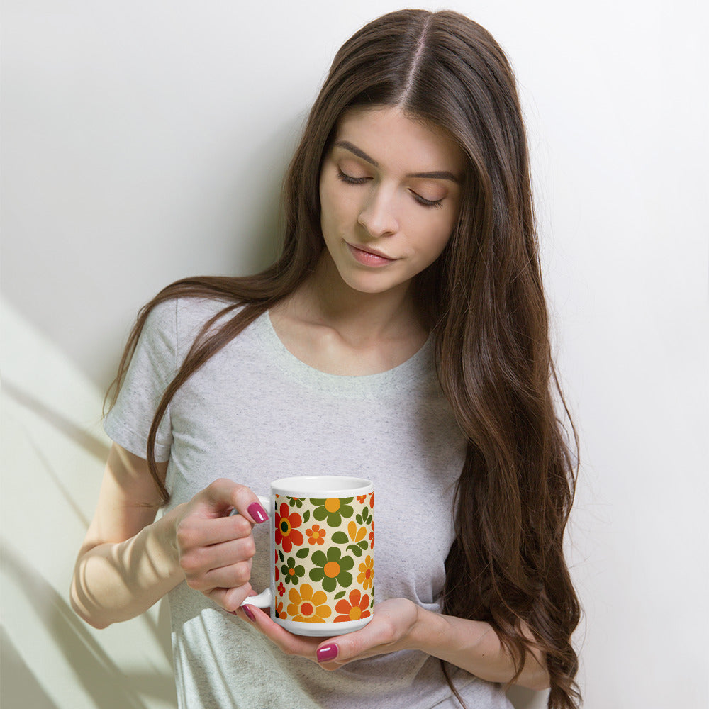 Groovy 1970s retro flower power pattern printed on a ceramic coffee mug with vibrant orange and yellow daisy graphics.