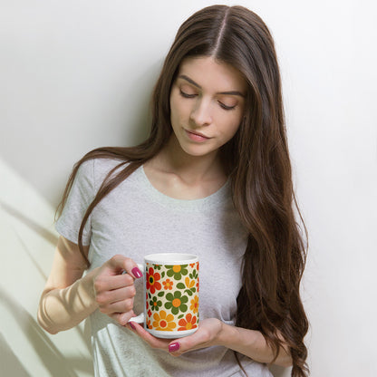 Groovy 1970s retro flower power pattern printed on a ceramic coffee mug with vibrant orange and yellow daisy graphics.