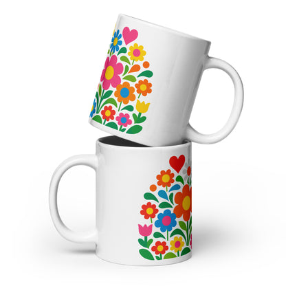 Vibrant 70s retro flower power bouquet with colorful blooms and pink and red hearts on a white ceramic mug.
