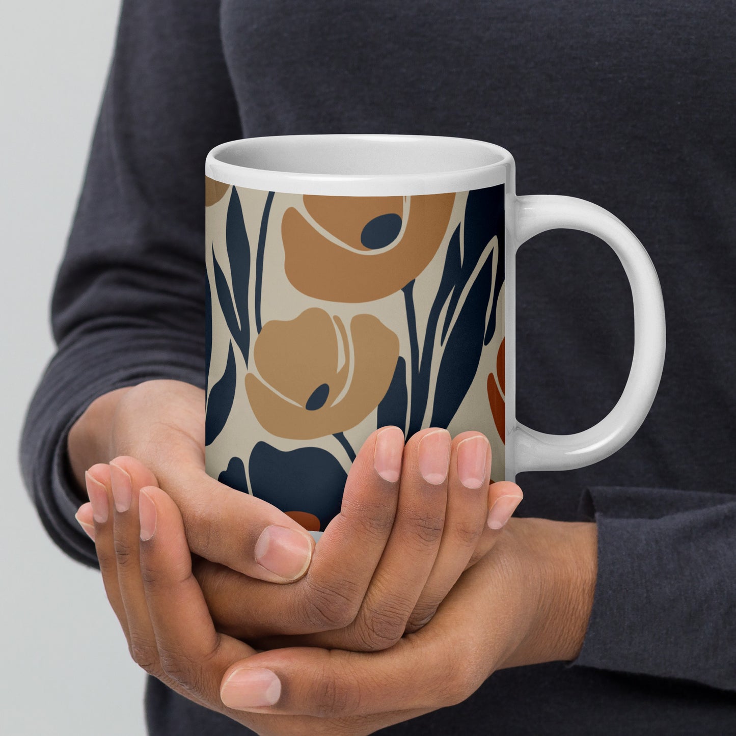 Ceramic coffee mug printed with a seamless retro floral pattern in earthy terracotta, ochre, and deep navy blue.