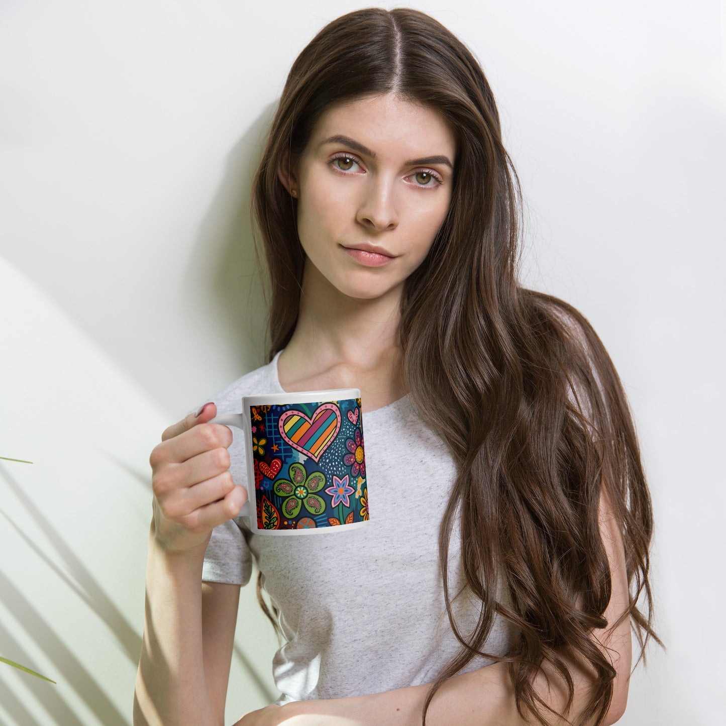 Vibrant retro psychedelic ceramic mug featuring colorful 60s flower power doodles and patterned hearts art.