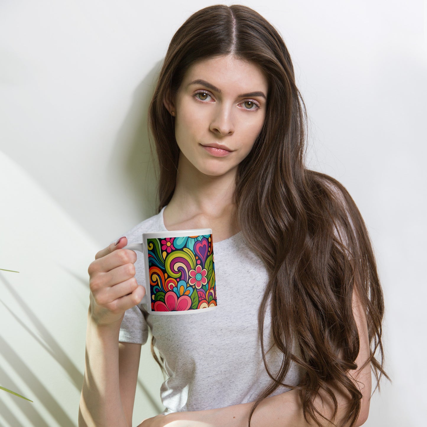 Vibrant retro 70s ceramic mug featuring a psychedelic doodle pattern of colorful flowers, groovy swirls, and hearts.
